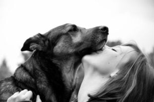 אישה מנשקת את הכלב שלה